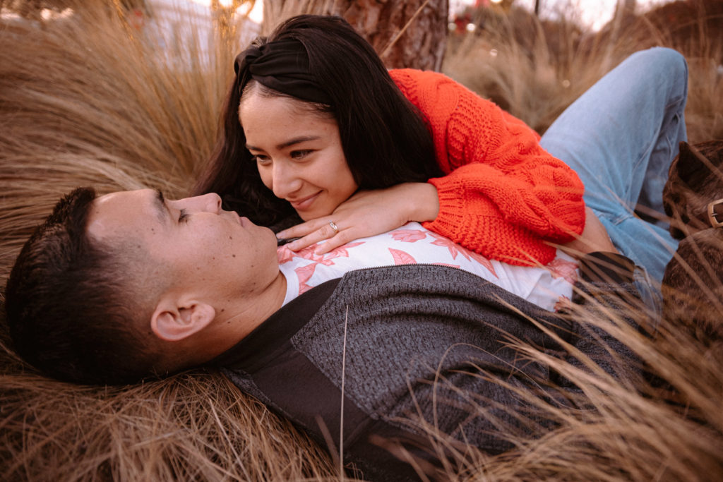 Couple lying down in dried grass