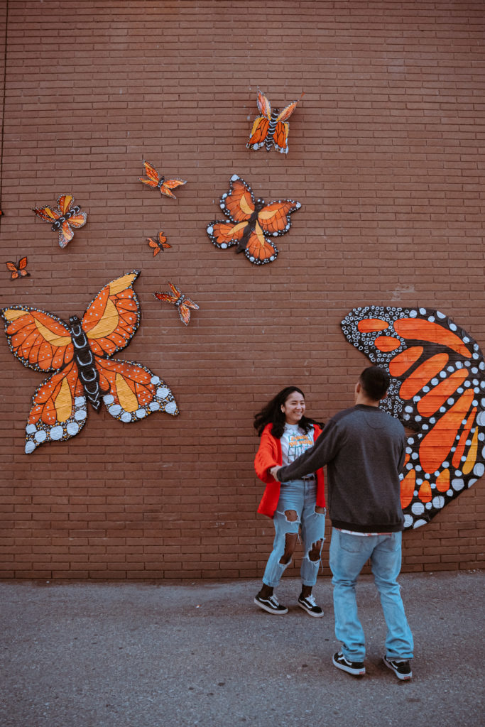 Dancing couple, in front of brick butterfly wall