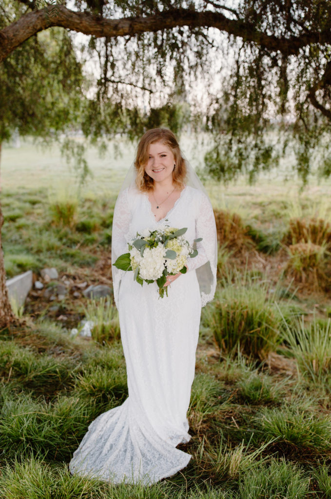 Bride smiling in field