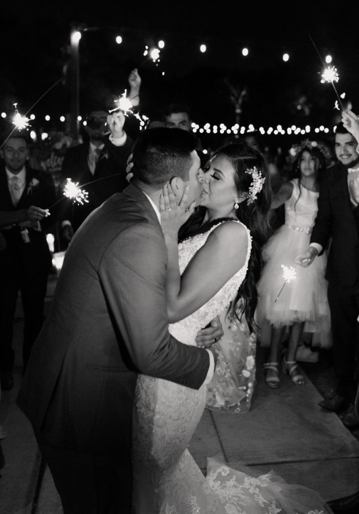 bride and groom kissing during a sparkler exit