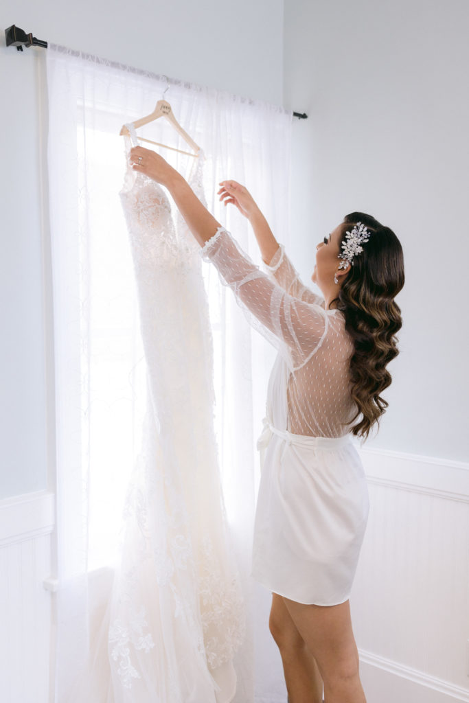 bride reaching for her dress while in bridal robe