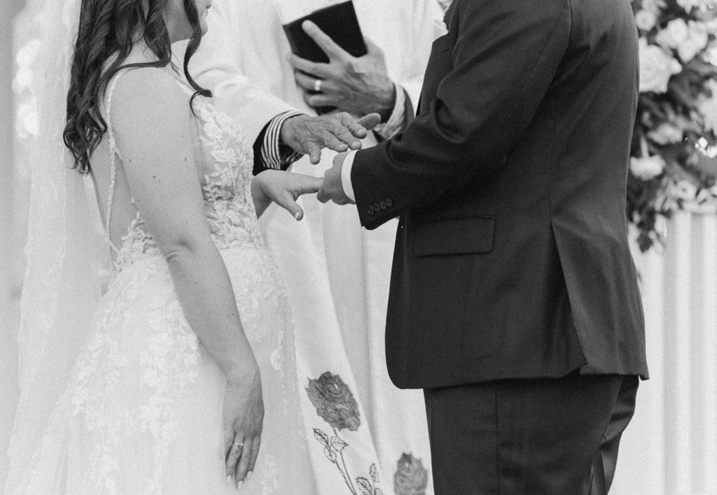 groom exchanges rings with bride