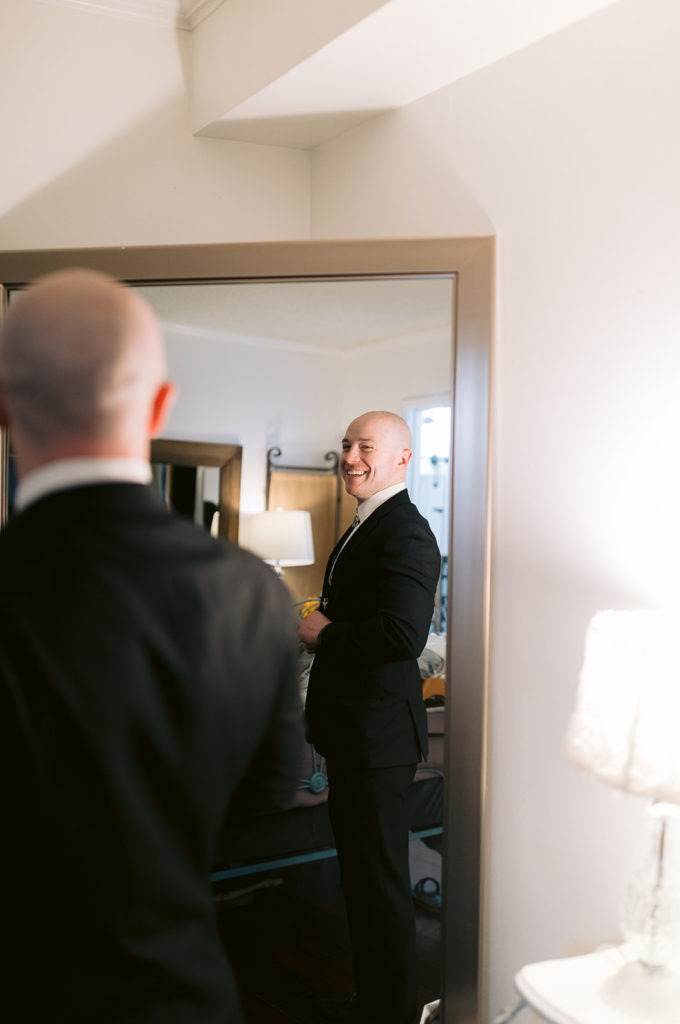 groom smiling while looking in the mirror