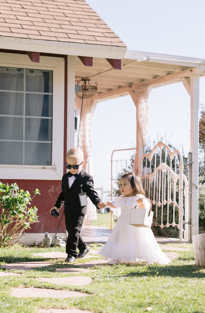 candid shot of ring bearer and flower girl walking down the aisle