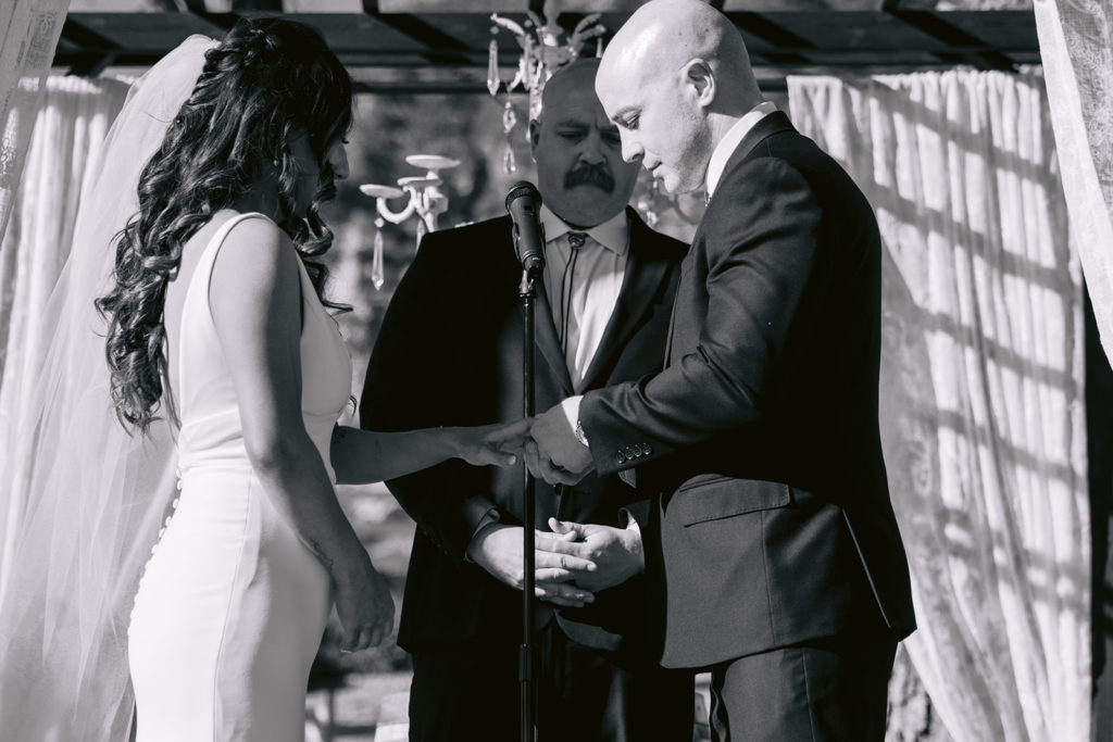 close up of groom exchanging rings during wedding ceremony