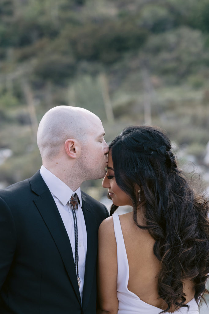 Groom kisses bride's forehead