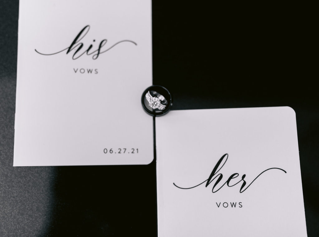 flatlay of vow books and bride's wedding ring
